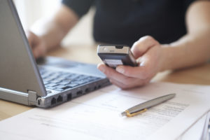 Woman Telephoning While Using Online Banking