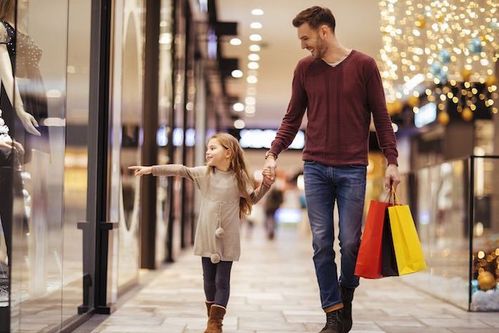 Dad and daughter walking through a mall