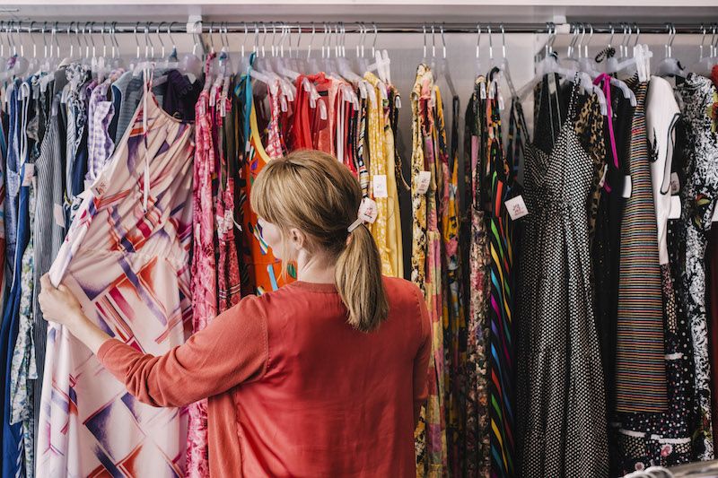 Woman looking at tops in a clothing store