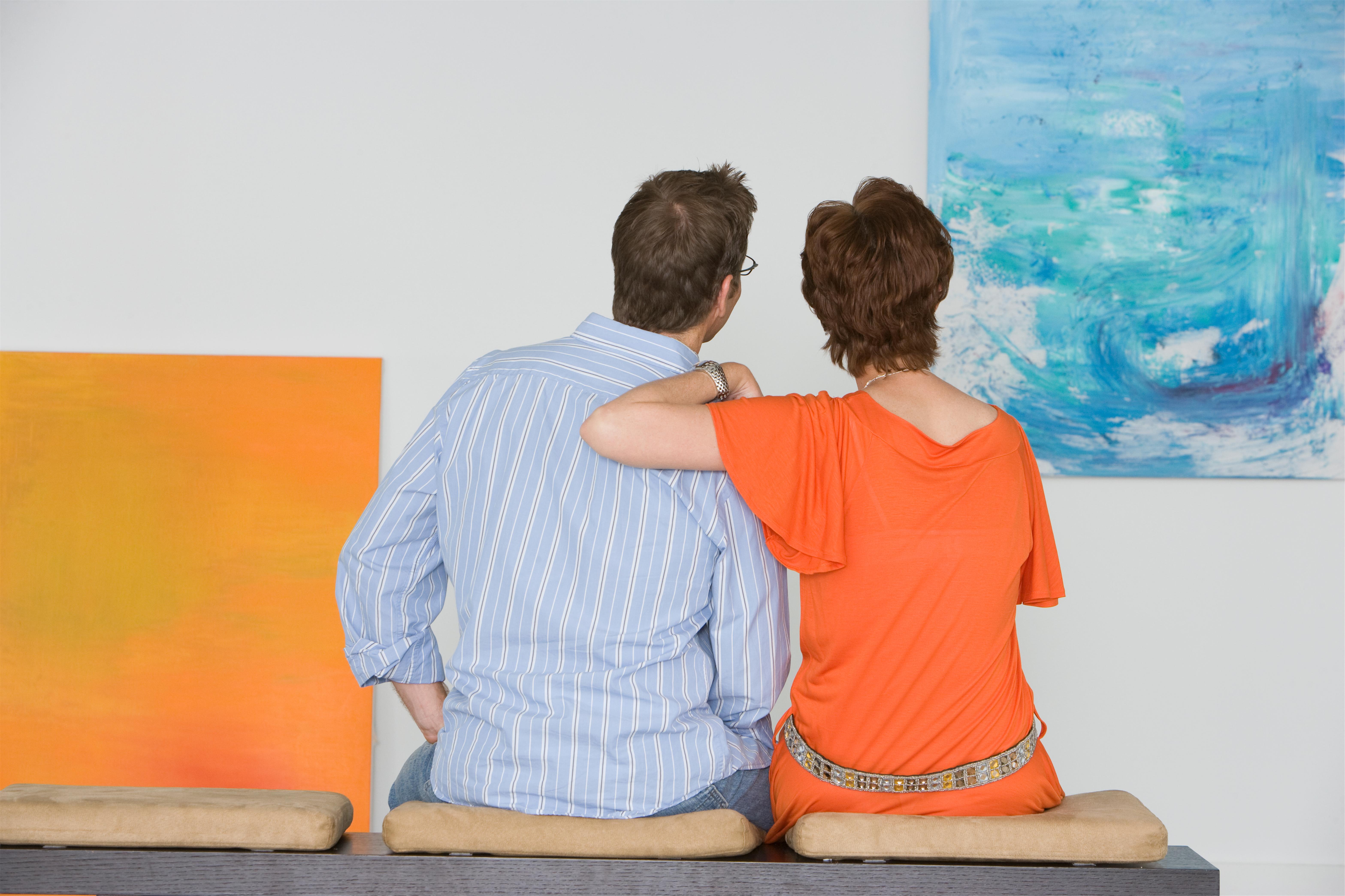 Couple contemplating paintings in gallery 2